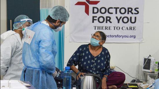 Health workers wearing PPE kits attend to a COVID-19 patient, at a temporary Covid hospital at Tau Devi Lal Stadium in Gurugram on Tuesday. (PTI)