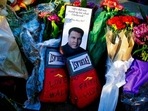 Boxing gloves and a message sit among flowers at a makeshift memorial to Muhammad Ali at the Muhammad Ali Center in Louisville, ky., in this Saturday, June 4, 2016, file photo. A new documentary looks at the city that raised Muhammad Ali, Louisville, Kentucky, and the week of his funeral, when the community came together to celebrate the legacy of “The Greatest.”(AP) Boxing gloves and a message sit among flowers at a makeshift memorial to Muhammad Ali at the Muhammad Ali Center in Louisville, ky., in this Saturday, June 4, 2016, file photo. A new documentary looks at the city that raised Muhammad Ali, Louisville, Kentucky, and the week of his funeral, when the community came together to celebrate the legacy of “The Greatest.”(AP)