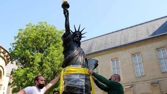 Workers put strap around a 2.83 meter original replica of the Statue of Liberty before being lifted by a crane from outside the Musee des Arts et Metiers in Paris before it departs for Ellis Island in New York to arrive on Independence Day, France, June 7, 2021. REUTERS/Noemie Olive(REUTERS)