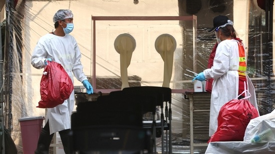 Staff wearing protective gear clean out waste from a Covid-19 testing site at the Hsinchu science park, following an increasing number of locally transmitted coronavirus disease cases, in Hsinchu, Taiwan, June 8, 2021. (Reuters)