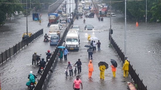 Commuters wade through a waterlogged road at Kings Circle in Mumbai, June 9. Waterlogging was reported in Hindmata, Gandhi Market in King Circle, Dadar TT, Dharavi, Govandi, Sion junction, and Behrambaug junction.(Shashank Parade / PTI)