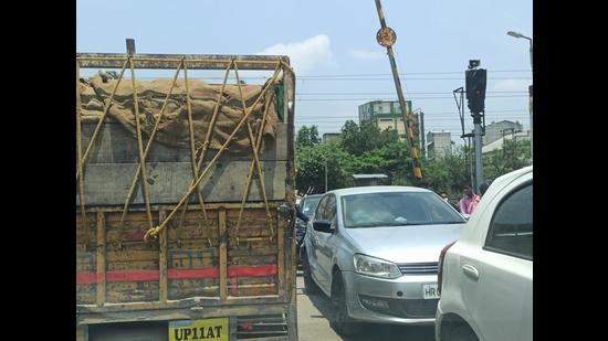 Cars, two-wheelers and three-wheelers can be seen squeezed between trucks and tractor trollies bound for the plywood factories across the crossing. (HT File) Cars, two-wheelers and three-wheelers can be seen squeezed between trucks and tractor trollies bound for the plywood factories across the crossing. (HT File)