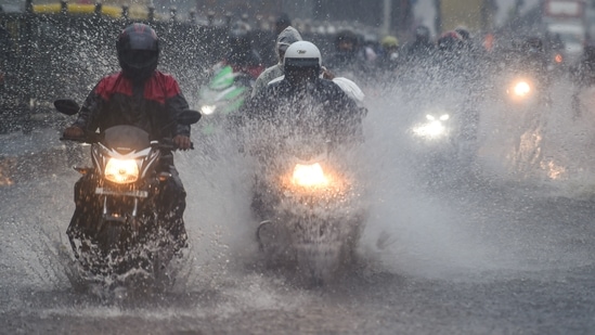 Commuters make their way through the waterlogged road during heavy rain, at Kings Circle, in Mumbai, on June 9. The India Meteorological Department (IMD) has already issued a yellow warning for the city of Mumbai anticipating heavy rainfall over the weekend.(Shashank Parade / PTI)