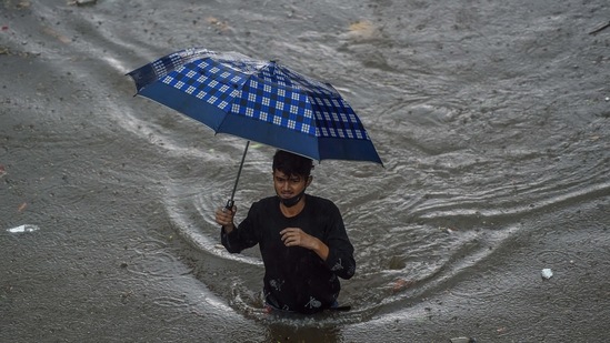 A man walks on a flooded road during heavy rains in Mumbai on June 9. Independent meteorologists have forecast that Mumbai may even see 450 to 600mm of rainfall accumulated in some places during the next four days, HT reported.(Punit Paranjpe / AFP)