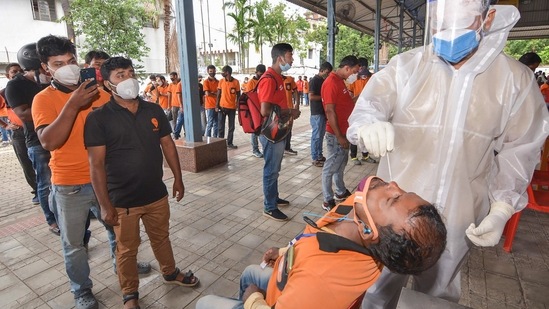 A health worker takes a swab sample from a food delivery executive for the Covid-19 testing, at a testing centre.(PTI) A health worker takes a swab sample from a food delivery executive for the Covid-19 testing, at a testing centre.(PTI)