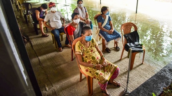 Beneficiaries wait to get COVID-19 vaccine at ESIS Hospital vaccination centre during heavy rain, in Navi Mumbai. (PTI Photo) Beneficiaries wait to get COVID-19 vaccine at ESIS Hospital vaccination centre during heavy rain, in Navi Mumbai. (PTI Photo)