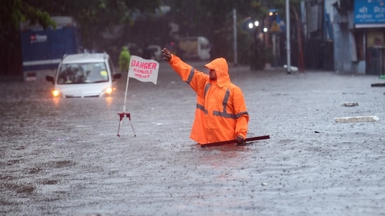 A BMC worker stands near a manhole to guide people on a waterlogged road at Kings Circle in Mumbai, Wednesday, June 9, 2021. (PTI) A BMC worker stands near a manhole to guide people on a waterlogged road at Kings Circle in Mumbai, Wednesday, June 9, 2021. (PTI)