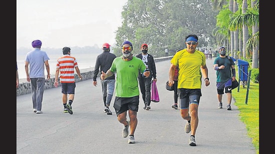 Residents enjoying a morning walk at the Sukhna Lake in Chandigarh on Wednesday. (KESHAV SINGH/HT)