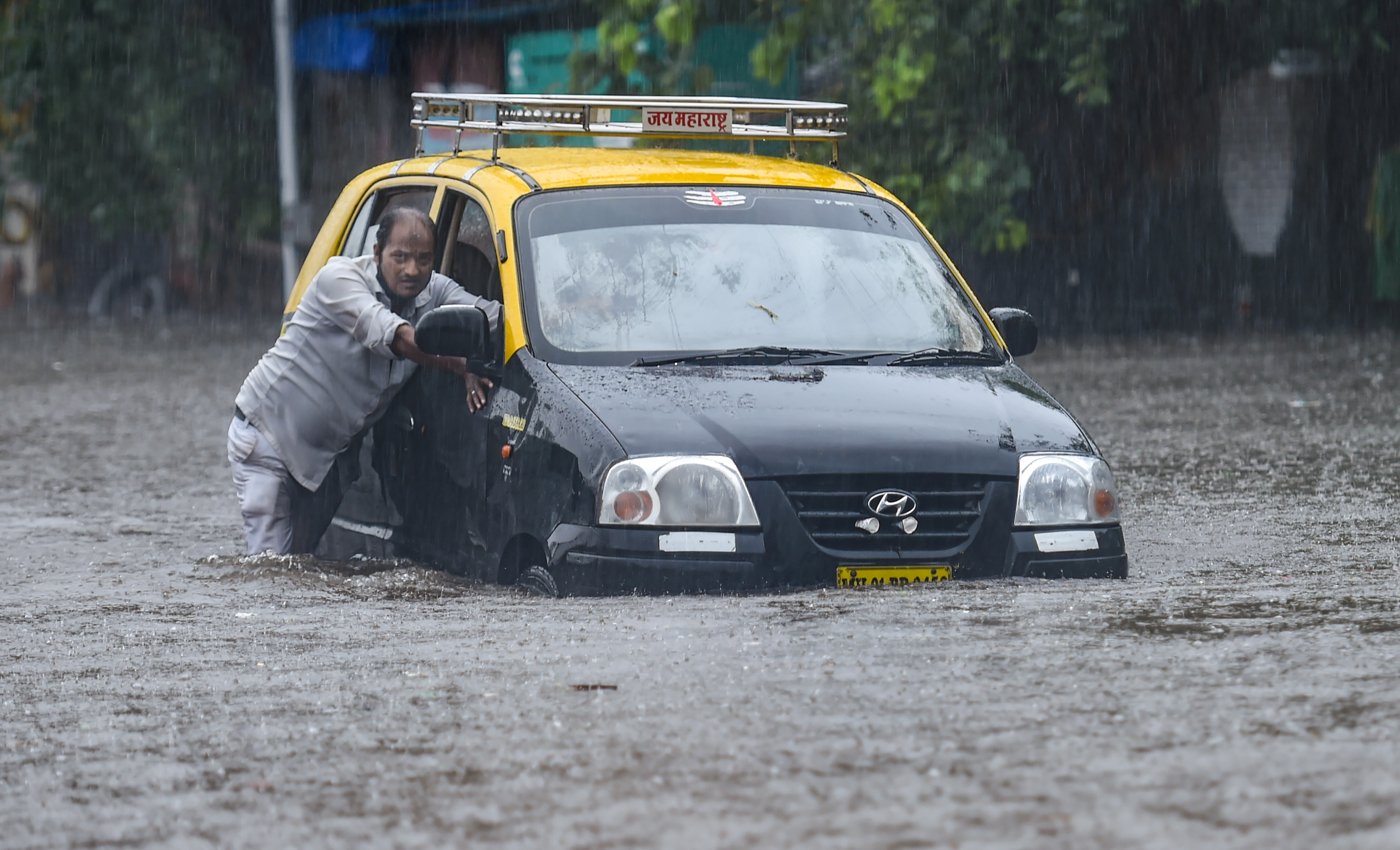A taxi driver pushes his car as he tries to wade through a waterlogged street at Hindmata in Mumbai, Wednesday, June 9, 2021. (PTI) A taxi driver pushes his car as he tries to wade through a waterlogged street at Hindmata in Mumbai, Wednesday, June 9, 2021. (PTI)