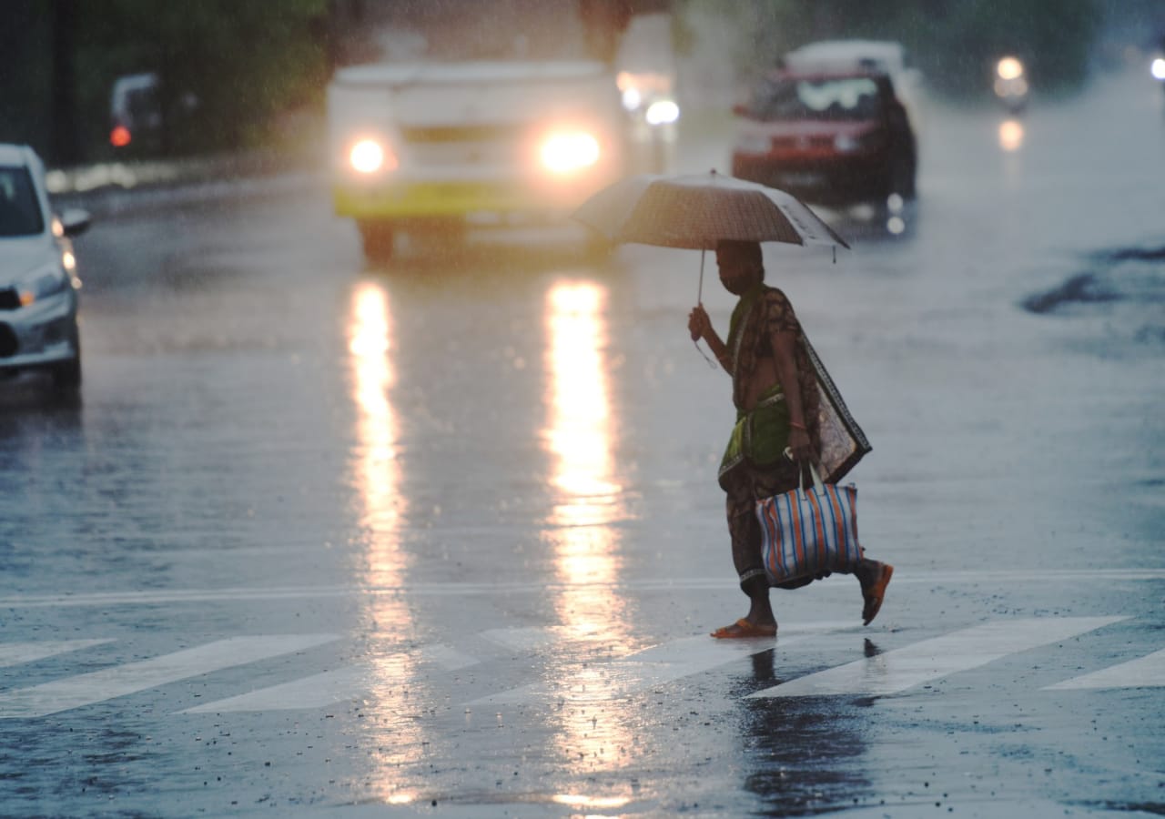A woman crosses street in Mumbai on Wednesday. The monsoon advanced for Maharashtra and larger Konkan coast, halting the daily life. (Satish Bate/ HT Photo)