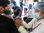A healthcare worker administers Covid-19 vaccine dose to a shopkeeper in Bhopal, on Tuesday.