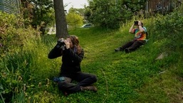 Avian ecologist and Georgetown University Ph.D. student Emily Williams, right, and a volunteer watch bird netting with binoculars from distance for American robins.