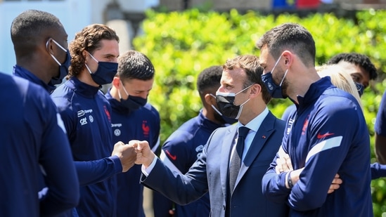 French President Emmanuel Macron greets players at the national soccer training camp in Clairefontaine-en-Yvelines.(AP)