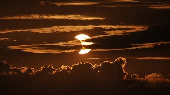 A partial solar eclipse seen behind clouds, in Arbutus, US on June 10. The solar eclipse was expected to be visible over the Earth's northern hemisphere on Thursday, June 10 with parts of Canada and Siberia privy to the best view of the celestial event, AFP reported.(Julio Cortez / AP)