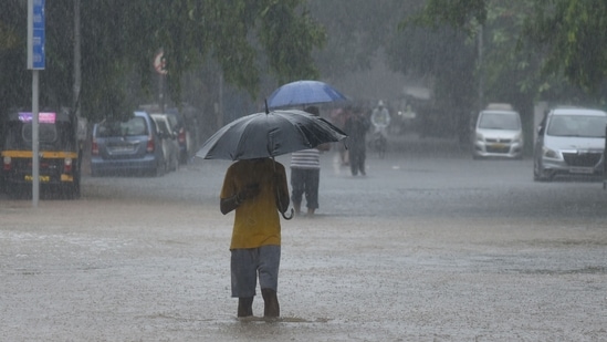 People make their way through the waterlogged road during heavy rains, near Khar Subway at Khar, in Mumbai, on June 9, 2021. (Vijay Bate/HT Photo)