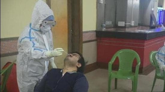 A Kolkata Municipal Corporation health staff member collects a swab sample from a man. (HT archive) A Kolkata Municipal Corporation health staff member collects a swab sample from a man. (HT archive)