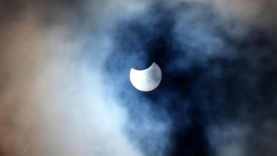 The partially eclipsed sun seen behind clouds, from Trafalgar Square in London, on June 10.(Frank Augstein / AP)