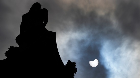 The partially eclipsed sun seen beside Nelson's Column in Trafalgar Square, London, on June 10.(Frank Augstein / AP)
