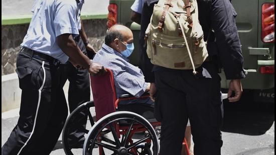 Mehul Choksi is taken in a wheelchair to the magistrate's court by police in Roseau, Dominica on June 4. (AP)