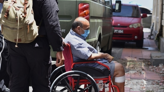 Mehul Choksi is taken in a wheelchair to the magistrate's court by police after his arrest for illegal entry into Dominica, in Roseau on June 4.(AP Photo)