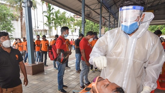 A health worker takes a swab sample from a food delivery executive for the Covid-19 testing, at a testing centre. (PTI)