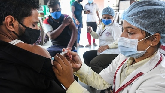 A healthcare worker administers Covid-19 vaccine dose to a shopkeeper in Bhopal, on Tuesday.(PTI Photo)