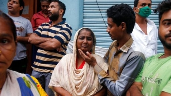 A woman whose house was damaged cries as she waits with other residents outside the building.(AP)