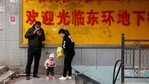 A family stands at the entrance to an underground retail street in Aksu in western China's Xinjiang Uyghur Autonomous Region.(AP) A family stands at the entrance to an underground retail street in Aksu in western China's Xinjiang Uyghur Autonomous Region.(AP)