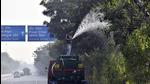 A PWD worker sprays water on trees as a pollution control measure. (HT Archive) A PWD worker sprays water on trees as a pollution control measure. (HT Archive)