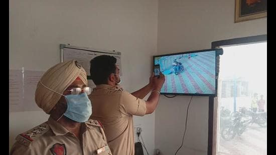 Investigating officers scrutinising the footage of CCTV cameras installed at the petrol pump near Phullanwal to gather clues about the robbers, in Ludhiana on Friday. (HT PHOTO)