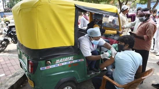 Health workers administer the Covid-19 vaccine to auto-rickshaw drivers outside the railway station in Ranchi, Jharkhand, on Tuesday. (PTI)