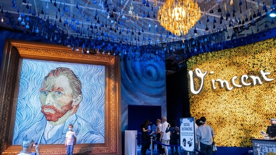 Guests arrive beside a giant replica of celebrated painter Vincent Van Gogh's self portrait during a preview of the Immersive Van Gogh exhibit at Pier 36, Friday, June 4, 2021, in New York. (AP)