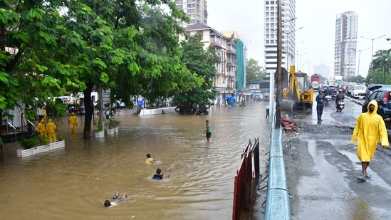Children playing on a waterlogged street during the rains at Parel in Mumbai on June 9. Apart from the waterlogging on the city’s roads, disruptions have already been experienced along the suburban train network due to tracks being inundated.(Bhushan Koyande / HT Photo)
