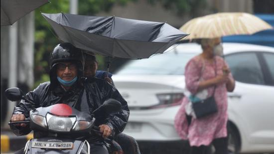 Mumbai, India - June 10, 2021: The umbrella held by the pillion rider turns upside during heavy rain at Dadar, in Mumbai, India, on Thursday, June 10, 2021. (Photo by Satish Bate/Hindustan Times) (Satish Bate/HT PHOTO)