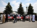 The funeral procession later proceeded for a private burial. In picture - Flag-wrapped coffins are seen outside the Islamic Centre of Southwest Ontario.(Reuters)