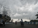 Motorists make their way along a road as dark monsoon clouds loom over Siliguri on June 11, 2021. (Diptendu DUTTA / AFP) Motorists make their way along a road as dark monsoon clouds loom over Siliguri on June 11, 2021. (Diptendu DUTTA / AFP)