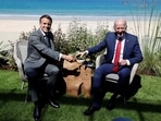 Biden, asked by a reporter if America was back, turned to Macron and gestured with his sunglasses towards the French president that he should answer that question. (Photo by Ludovic MARIN / AFP)(AFP) Biden, asked by a reporter if America was back, turned to Macron and gestured with his sunglasses towards the French president that he should answer that question. (Photo by Ludovic MARIN / AFP)(AFP)