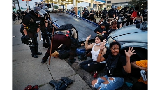 Protesters with their hands hands raised on command from police as they are detained prior to arrest and processing at a gas station on South Washington Street, May 31, 2020, in Minneapolis.(John Minchillo / AP Photo)
