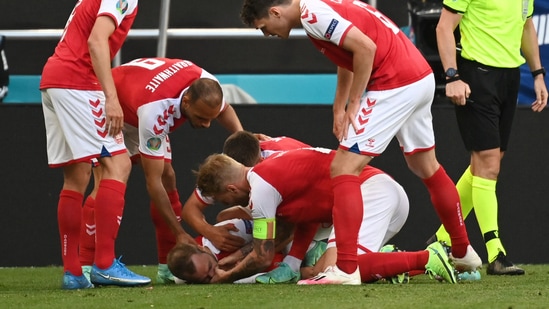 Denmark's Christian Eriksen receives medical attention after collapsing during the match.(Pool via REUTERS)