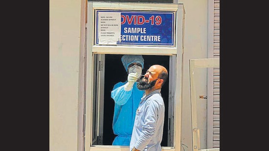 A health worker collecting a swab sample for Covid testing from a man in Srinagar on Saturday. (Waseem Andrabi/HT) A health worker collecting a swab sample for Covid testing from a man in Srinagar on Saturday. (Waseem Andrabi/HT)