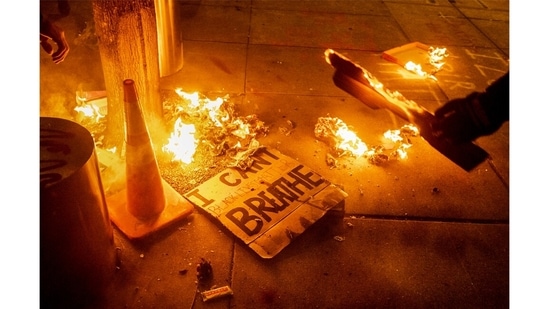 A Black Lives Matter protester burns a sign outside the Mark O. Hatfield United States Courthouse on July 21, 2020 in Portland, Oregon(Noah Berger / AP Photo)