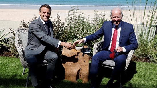 Biden, asked by a reporter if America was back, turned to Macron and gestured with his sunglasses towards the French president that he should answer that question. (Photo by Ludovic MARIN / AFP)(AFP)