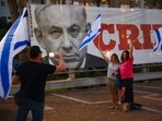 Israelis pose in front of a poster showing outgoing Israeli prime minister Benjamin Netanyahu in Tel Aviv, Israel. Israelis pose in front of a poster showing outgoing Israeli prime minister Benjamin Netanyahu in Tel Aviv, Israel.