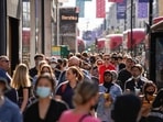 Pedestrians, some wearing face coverings due to Covid-19, walk past shops on Oxford Street in central London. Pedestrians, some wearing face coverings due to Covid-19, walk past shops on Oxford Street in central London.