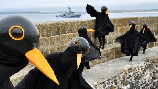 Climate change activists dressed up as black birds protest in St. Ives, on the sidelines of the G7 summit in Cornwall, England on June 11. The harbour town in southwest England is being used to host a media centre for reporters from around the world covering the first in-person gathering of the elite group since 2019.(Dylan Martinez / REUTERS)