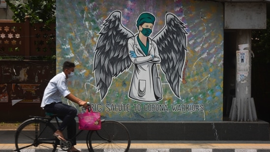 A cyclist rides past a Corona warrior mural at ITO in New Delhi, India, (Sanchit Khanna/HT PHOTO) A cyclist rides past a Corona warrior mural at ITO in New Delhi, India, (Sanchit Khanna/HT PHOTO)