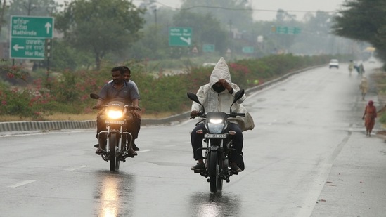 Commuters out in the rain along Bathinda -Amritsar Road. (Photo by Sanjeev Kumar/Hindustan Times)&nbsp;