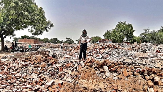 A man stands on the rubble of demolished houses in Jewar’s Nagla Ganeshi, one of the seven villages that have been acquired for construction of an international airport. (HT Photo)