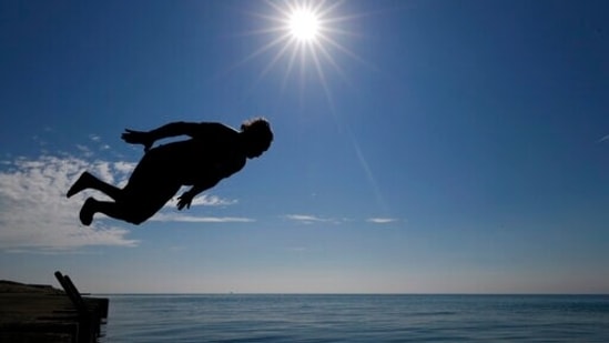 Dan O'Conor is silhouetted as he makes his daily leap into Lake Michigan.(AP) Dan O'Conor is silhouetted as he makes his daily leap into Lake Michigan.(AP)
