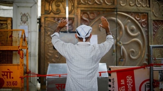A man prays outside a temple, in New Delhi, on June 14. Visitors are still not allowed inside religious places under the guidelines.(Adnan Abidi / REUTERS)